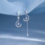 Asymmetrical earrings with moon, star, crystal, and pearl details